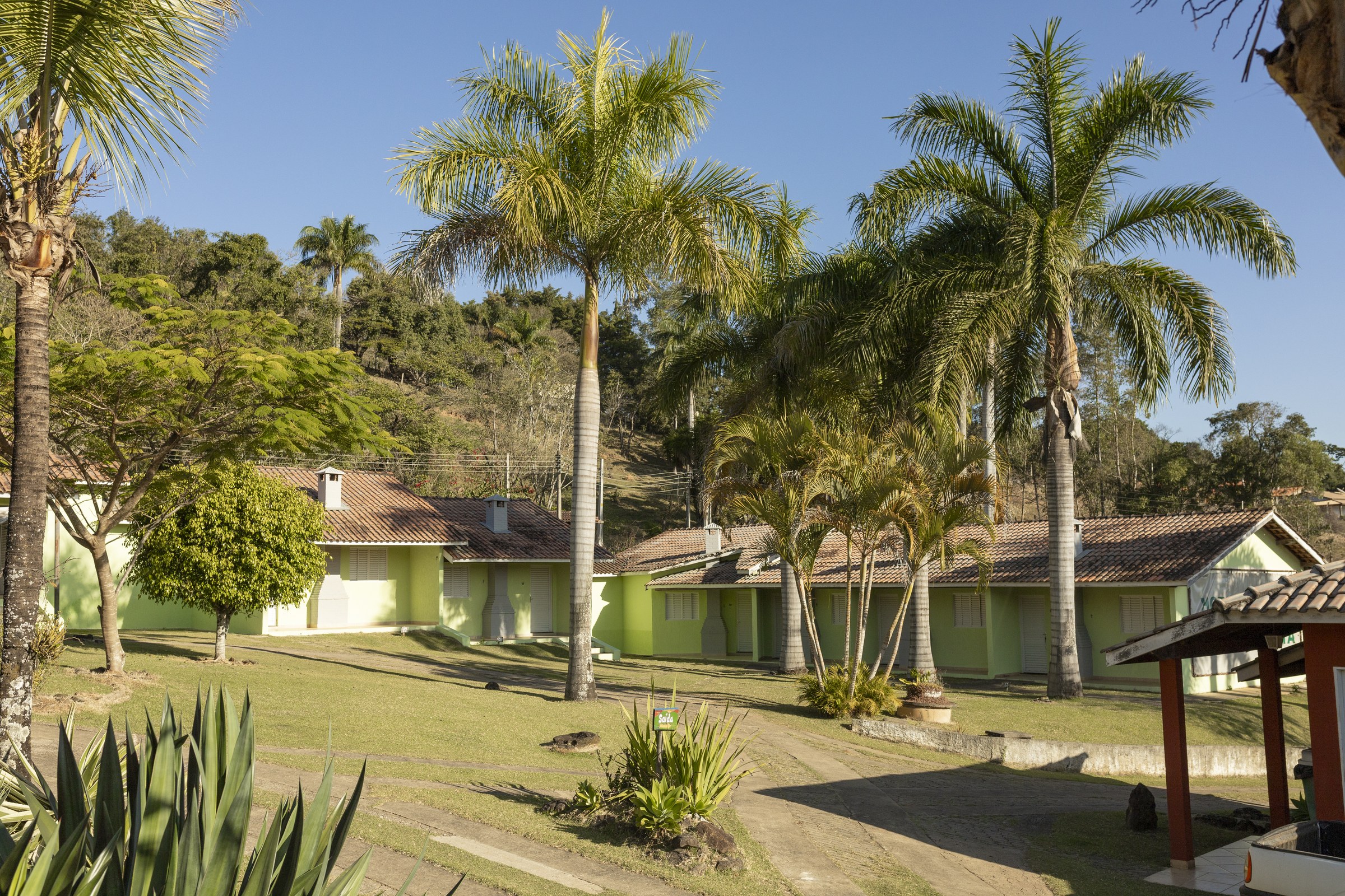 Chalés distribuídos entre palmeiras e jardins do Recanto Maria Bonita